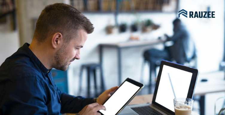 Homem bem arrumado utilizando um tablet enquanto trabalha no computador