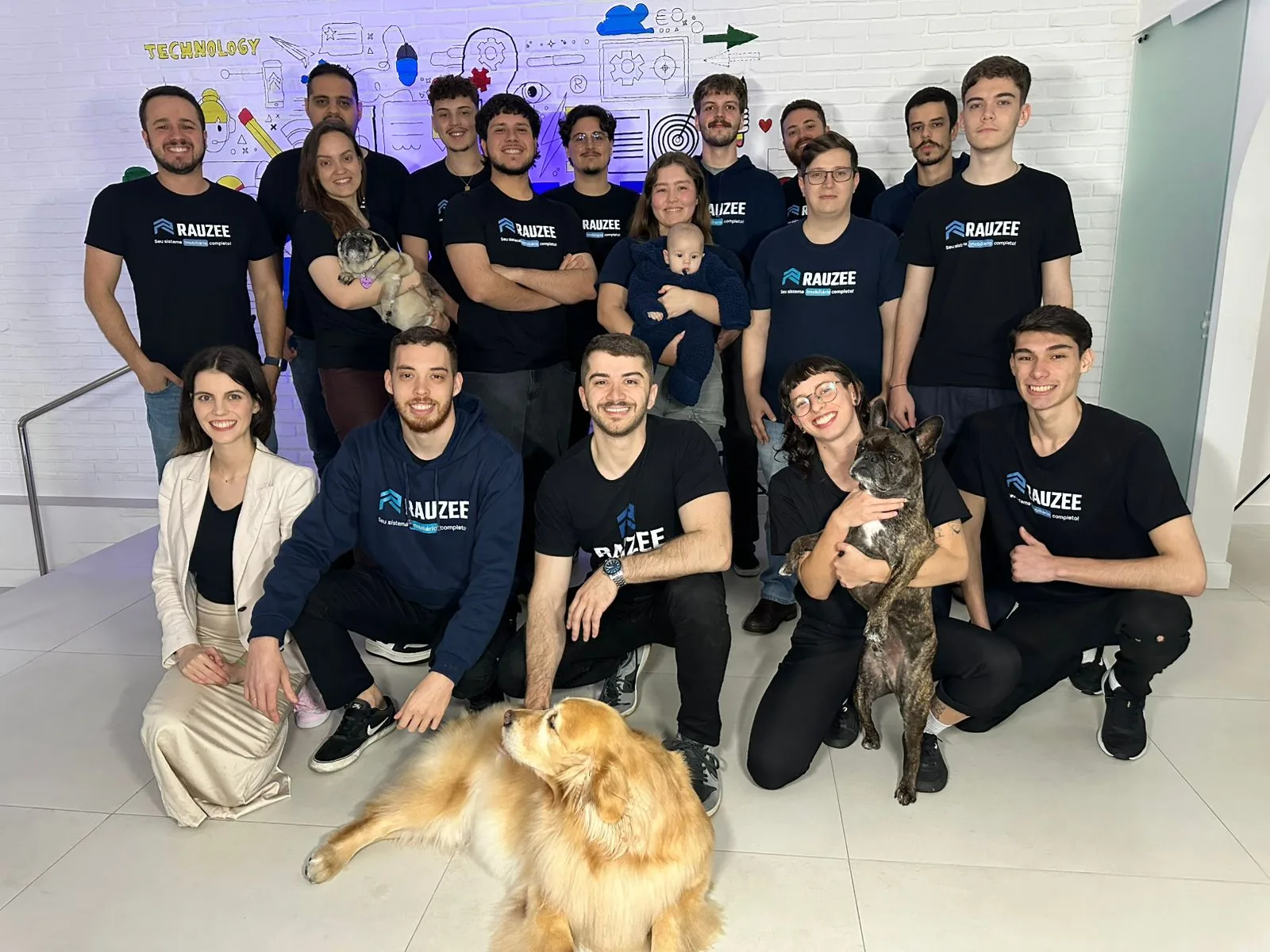 Time da Rauzee reunido no escritório, de camiseta da marca
