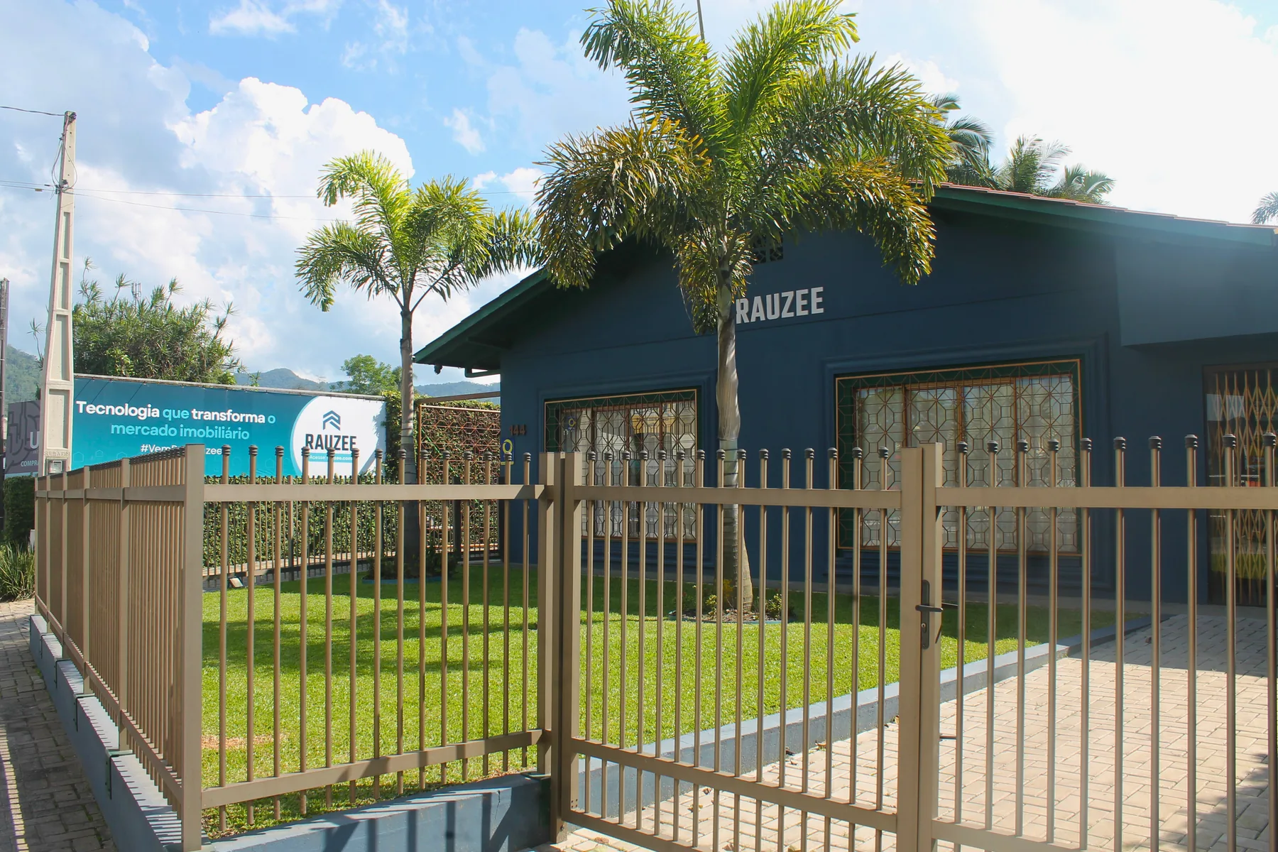 Fachada do escritório da Rauzee em Jaraguá do Sul, casa azul com o nome na parede